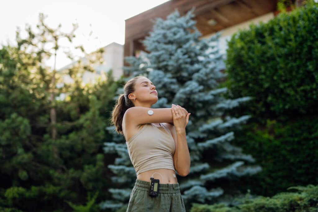 Beautiful diabetic woman preparing for outdoor run in the city. Young woman wearing an insulin pump during exercising. Concept of exercise and diabetes.